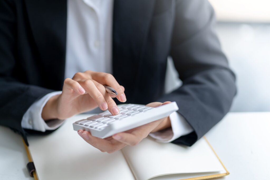 A woman using a white calculator.