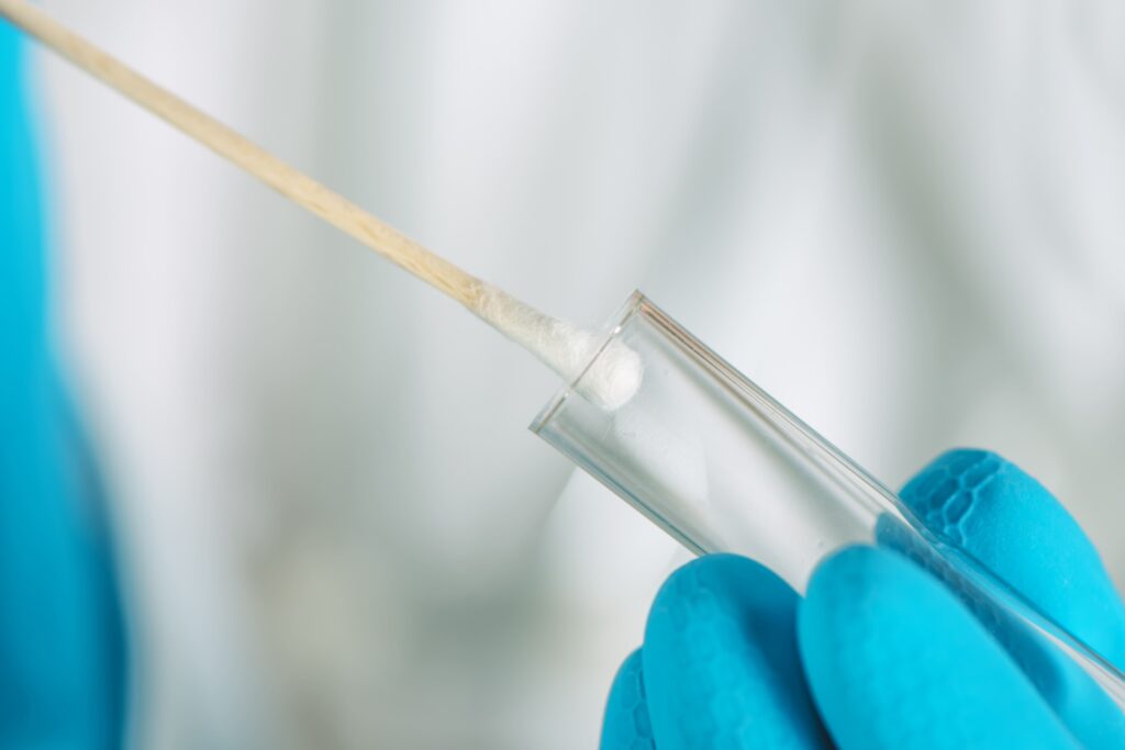 A closeup image of a cotton swab and DNA tube, symbolizing the role of DNA testing in paternity cases.