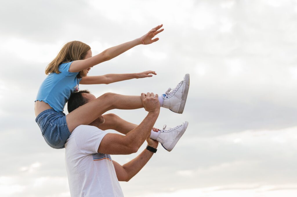 A father playing with his daughter, showing a positive parental role.