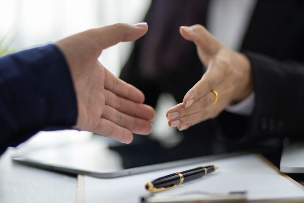 Handshake between a lawyer and a client after successful negotiation, representing protection of interests.