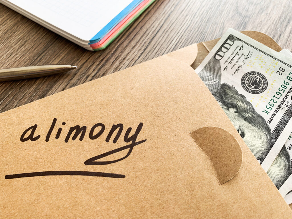 Brown envelope with the word alimony, and money.